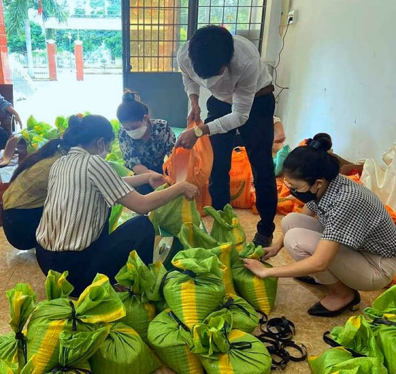 Tình nguyện viên huyện Cư M'gar chuẩn bị gạo cho túi quà an sinh