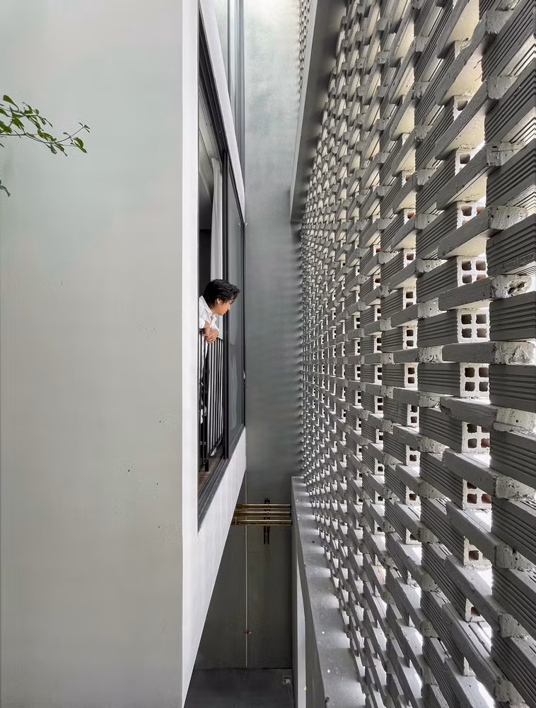 Bên ngoài ngôi nhà, những viên gạch đất sét nung được xếp lồng vào nhau, tạo ra những bức tường với hơn 50% không gian trống.