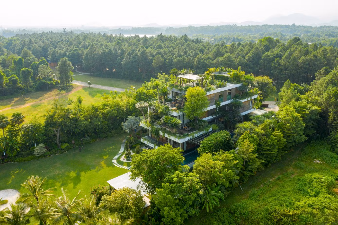 Không gian của biệt thự bao gồm những khu vườn xanh mát, được quy hoạch tổng thể kết hợp với bể bơi, khu vui chơi, địa hình cao thấp tạo nên kiến trúc xanh hài hòa.