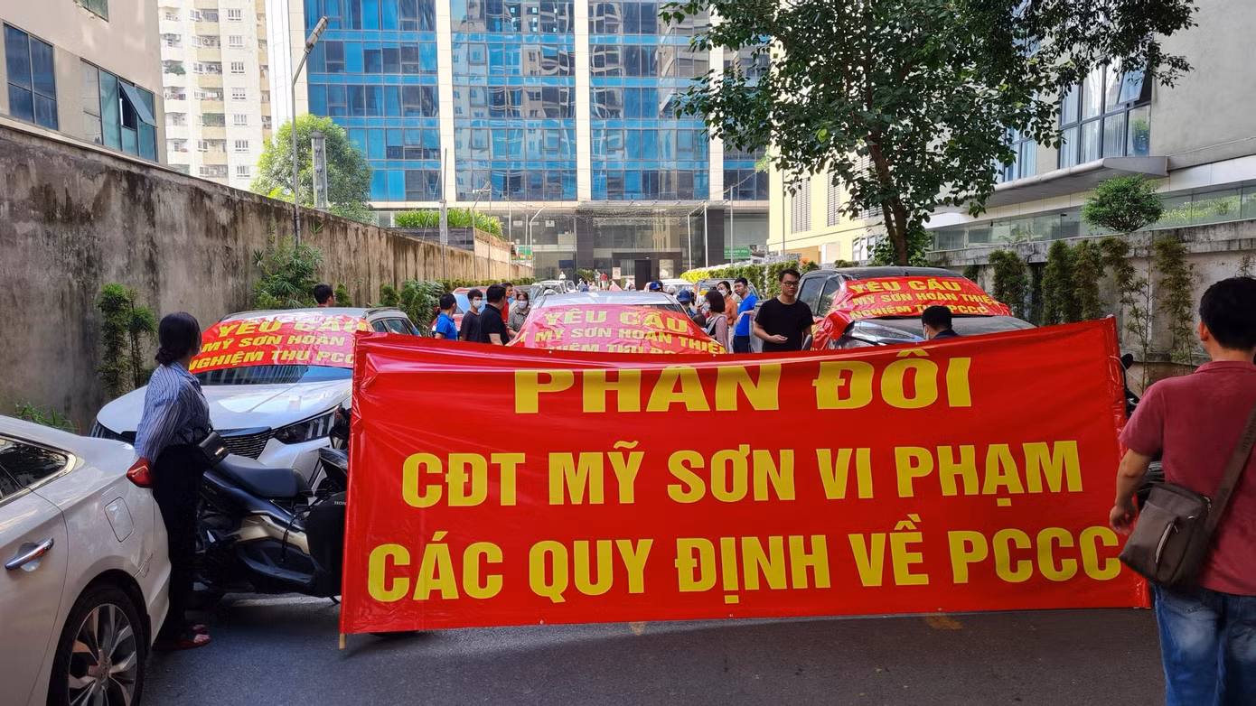Cư dân đang sinh sống tại chung cư Mỹ Sơn 62 Nguyễn Huy Tưởng, phường Thanh Xuân Trung (quận Thanh Xuân, Hà Nội) tập trung trước dự án băng rôn kêu cứu về những bất cập, tồn tại của tòa nhà, đặc biệt là như những vi phạm về PCCC.