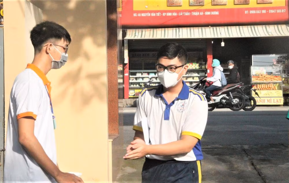 Học sinh được sát khuẩn và hướng dẫn đến khu vực làm thủ tục