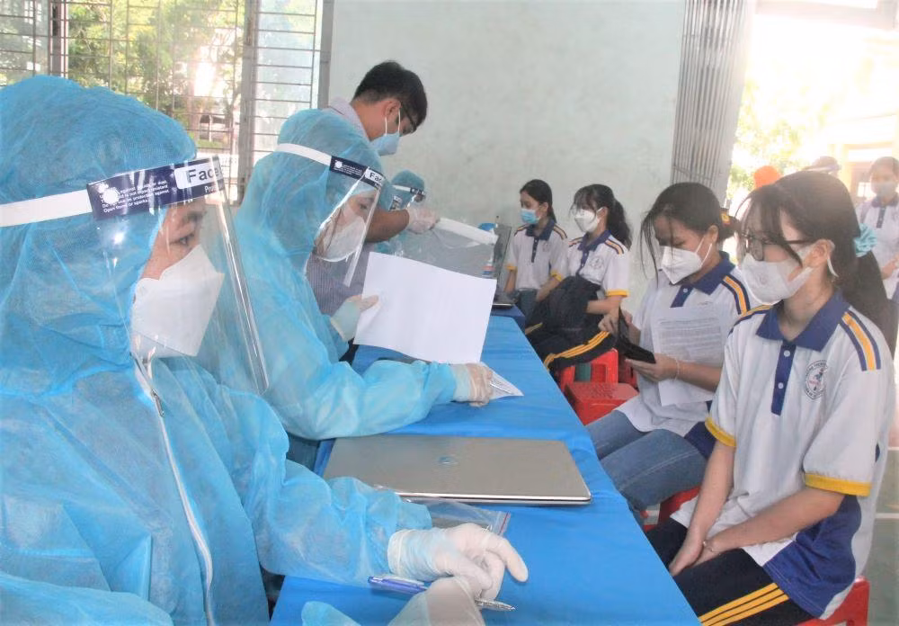 Học sinh được nhân viên y tế tư vấn trước khi tiêm