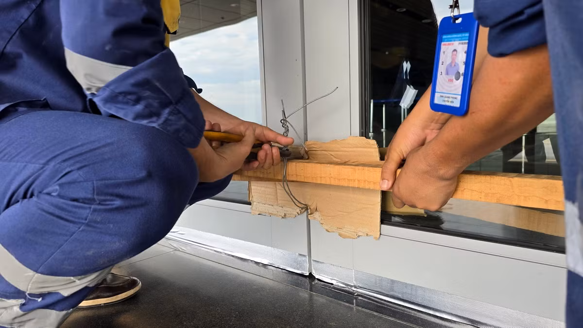 Nhân viên kỹ thuật chằng néo, gia cố chắc chắn các cánh cửa khu vực nhà ga sân bay Vân Đồn.