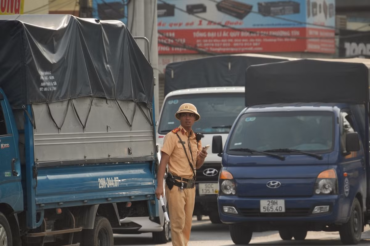 Lực lượng công an vất vả phân luồng các phương tiện đi lên cầu vượt đoạn qua thị trấn Thường Tín.