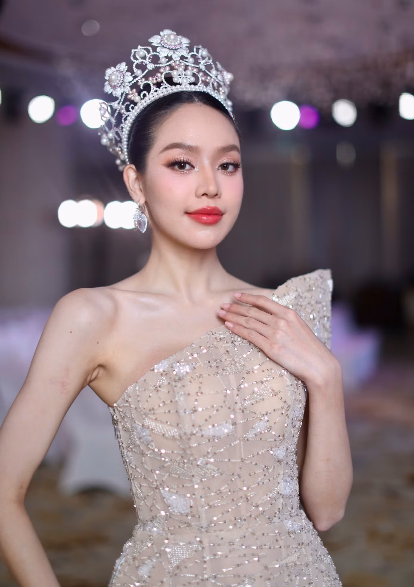 Thanh Thủy diện bộ váy sequin lệch vai màu nude trong buổi giao lưu. Thiết kế giúp người đẹp khoe vai trần thon thả, tôn lên vóc dáng thanh mảnh.