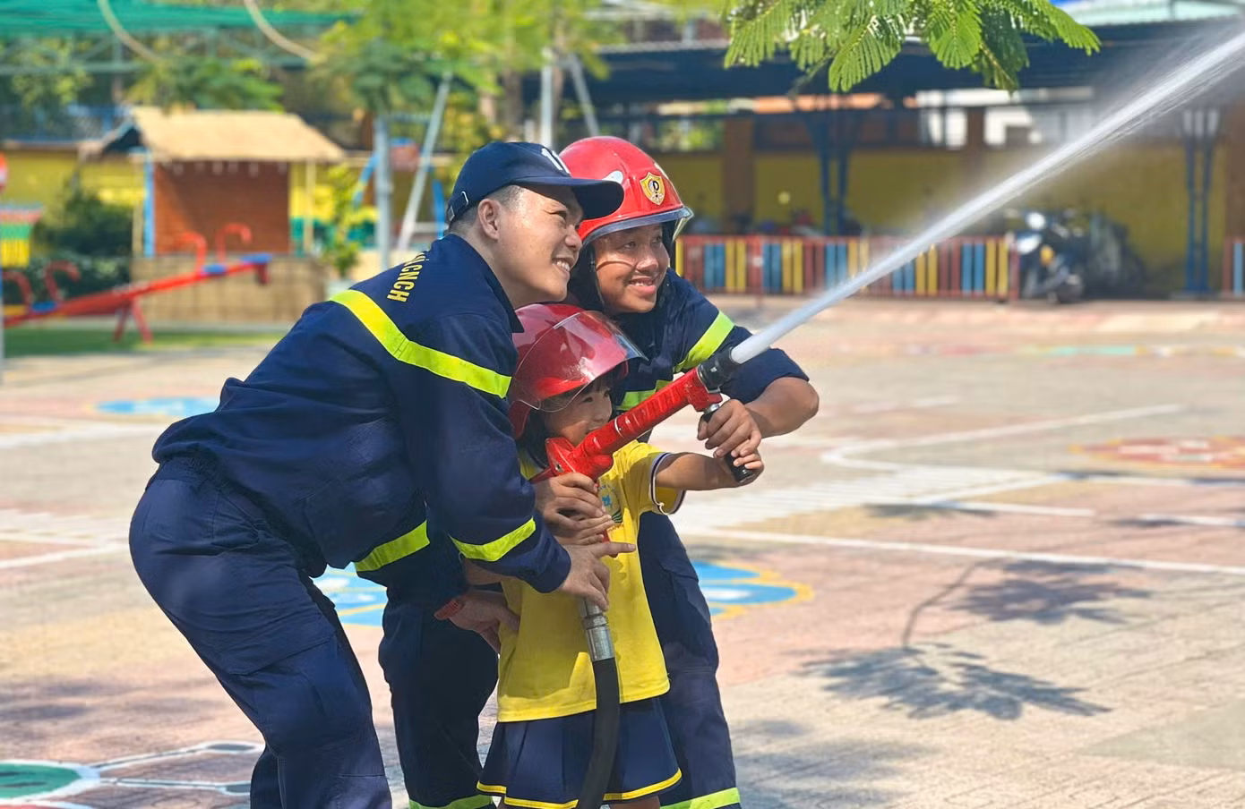Các em học sinh được trải nghiệm phun nước chữa cháy