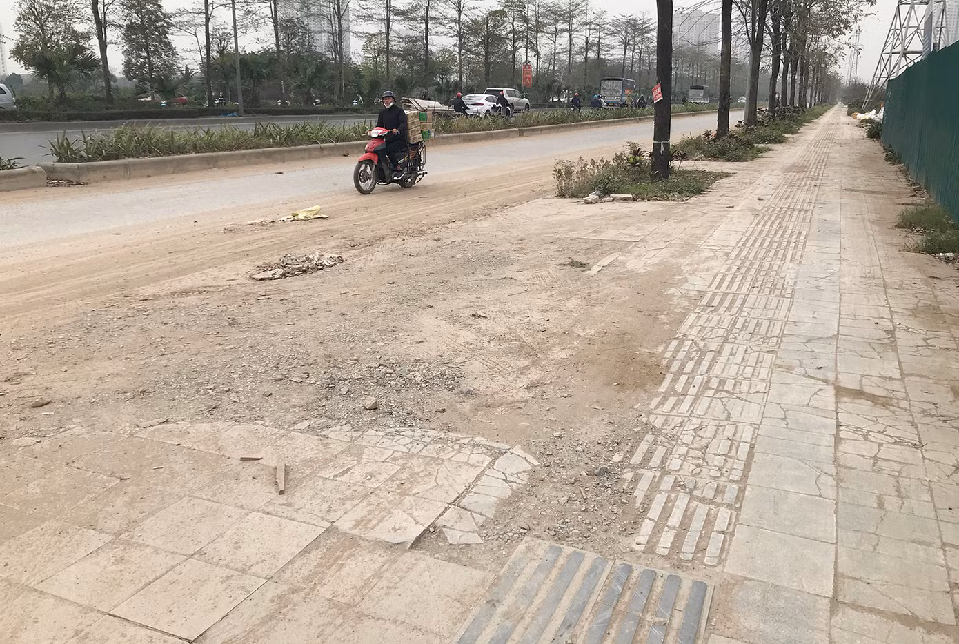 Trên tuyến đường này cũng đang thi công nhiều công trình lớn, nhiều phương tiện tải trọng nặng gây hư hỏng vỉa hè. Ảnh: Trường Phong.