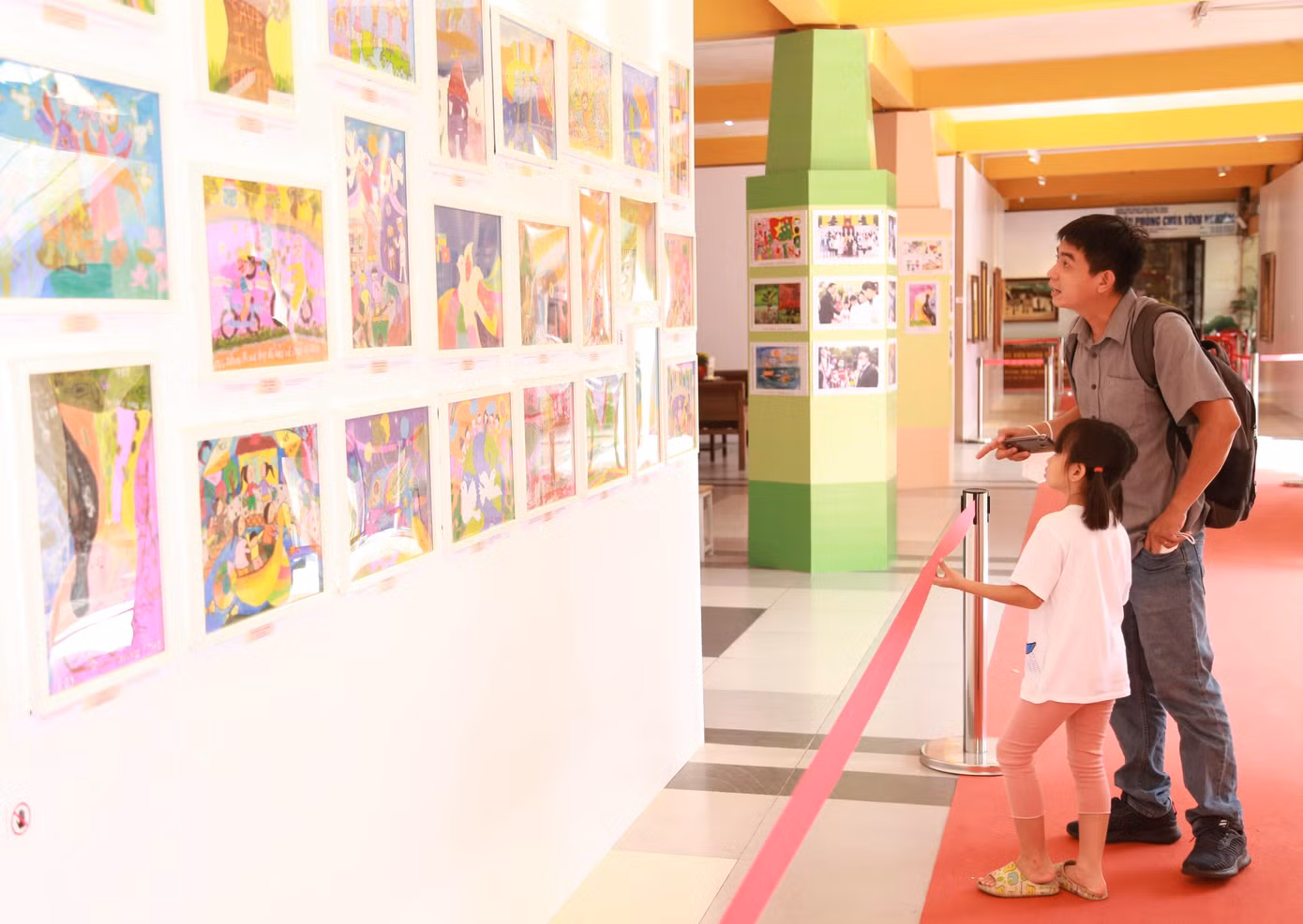 "Bé nhà mình rất thích vẽ tranh nên mình dẫn cháu đến xem và học hỏi thêm", vị phụ huynh nói khi đang dẫn con xem các bức vẽ được trưng bày tại chùa Vĩnh Nghiêm.