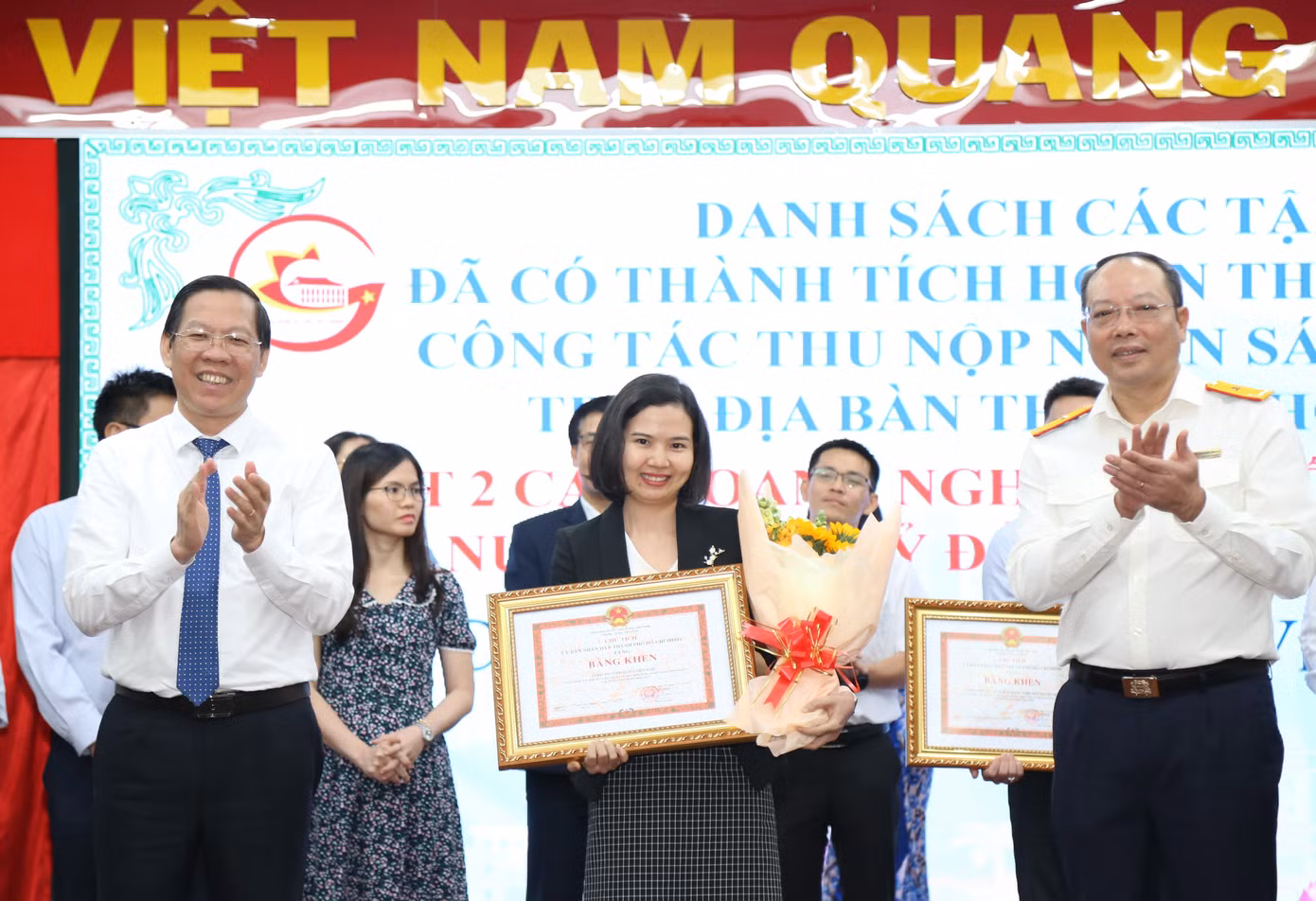 Chủ tịch UBND TPHCM Phan Văn Mãi và Phó Tổng Cục trưởng Tổng cục Thuế Vũ Xuân Bách trao bằng khen cho các doanh nghiệp có mức đóng góp ngân sách lớn.