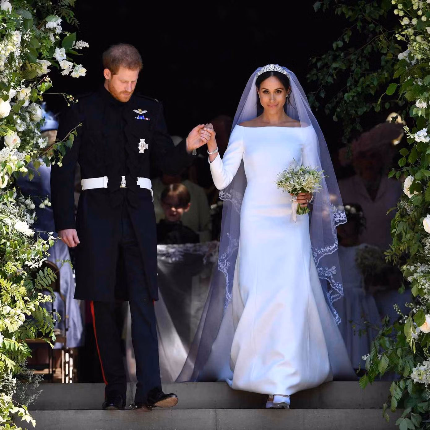 Chiếc váy cưới của Meghan Markle ước tính trị giá 110.000 bảng Anh (132.000 USD), do chính Nữ công tước xứ Sussex chi trả. Thiết kế là sản phẩm thủ công của Clare Waight Keller, đến từ nhà mốt Pháp Givenchy. Keller dành 3.900 giờ để thêu tấm màn dài 4,87 m với quốc hoa của 53 quốc gia và vùng lãnh thổ thuộc khối Thịnh vượng chung. Ảnh: Getty Images.