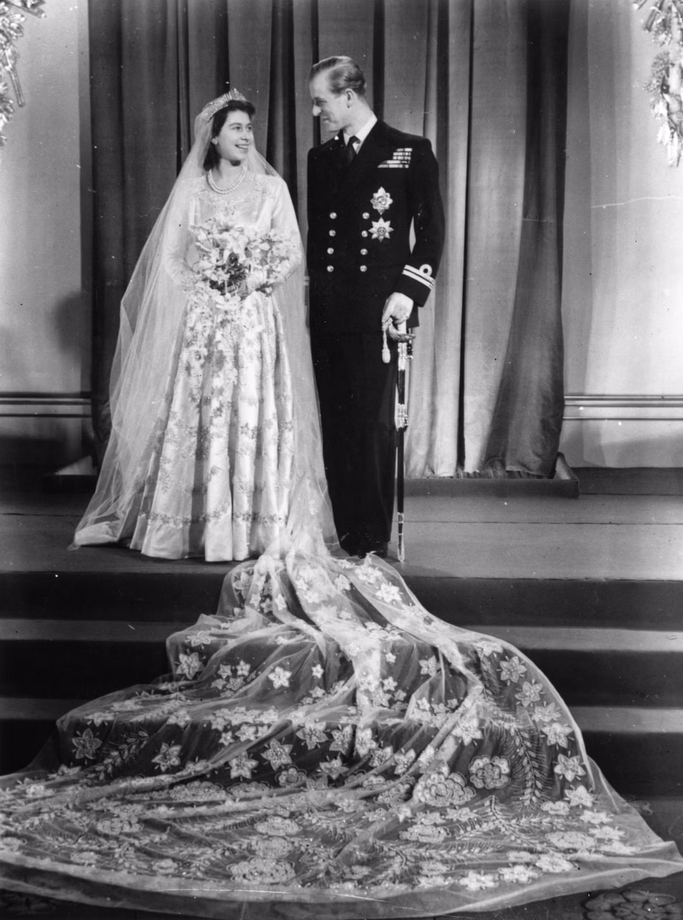 Dù váy cưới của cố Nữ hoàng Elizabeth II chỉ có giá 30.000 bảng Anh (36.000 USD tính theo mệnh giá hiện nay), thấp hơn nhiều so với những chiếc váy được đề cập ở trên, tuy nhiên chắc chắn đó là con số đáng kinh ngạc khi bà kết hôn với Hoàng tế Philip năm 1947. Nữ hoàng thậm chí phải thu thập phiếu giảm giá để chi trả cho váy cưới của mình. Nó được Norman Hartnell tạo ra bằng lụa Trung Quốc và tà dài 4,57 m. Váy được đính kết ngọc trai, kim cương, cùng nhiều họa tiết hoa hồng, hoa nhài và lúa mì. Ảnh: Getty Images.