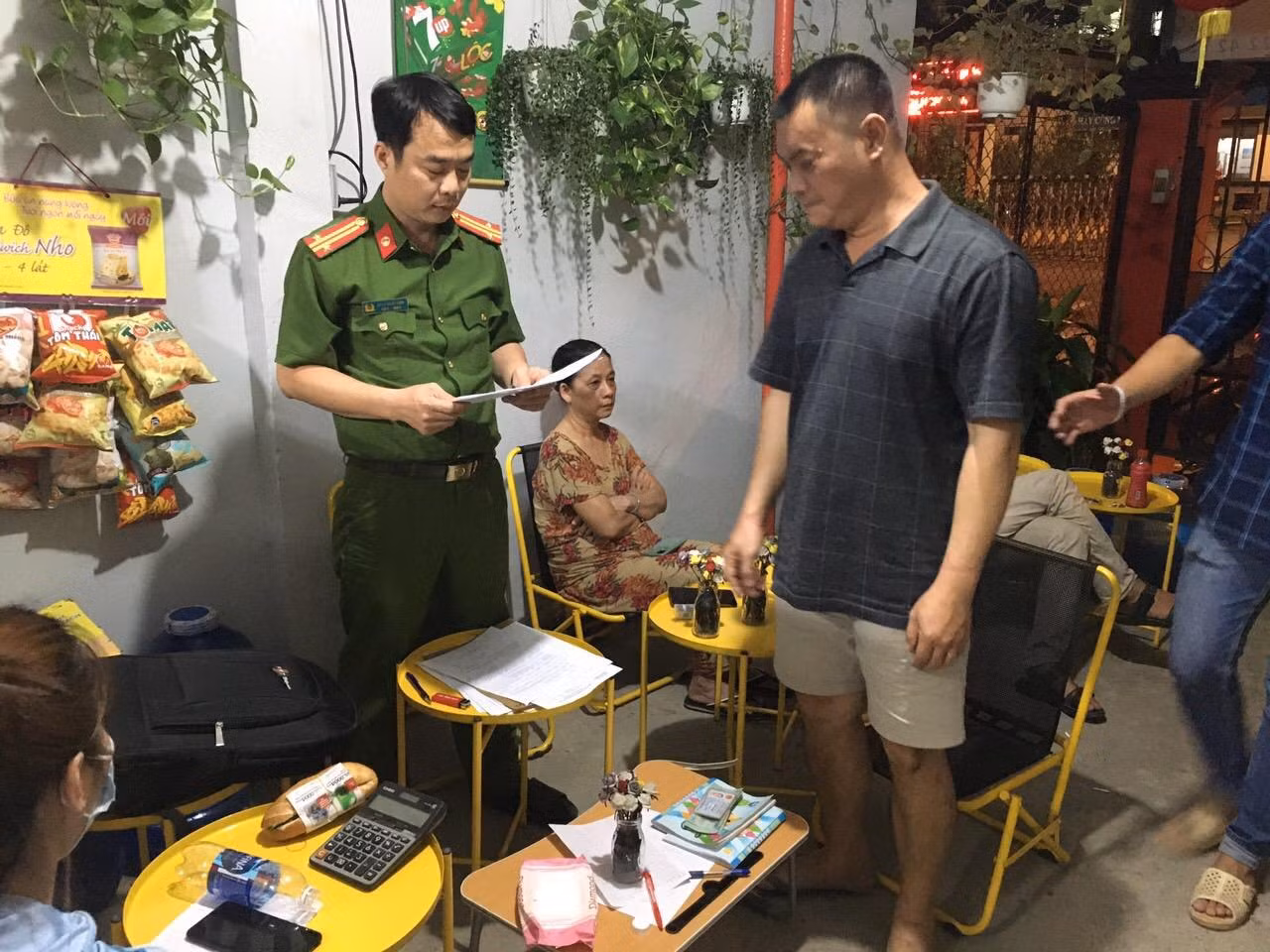 Công an đọc lệnh khám xét, bắt một đối tượng trong đường dây cờ bạc này. Ảnh CA