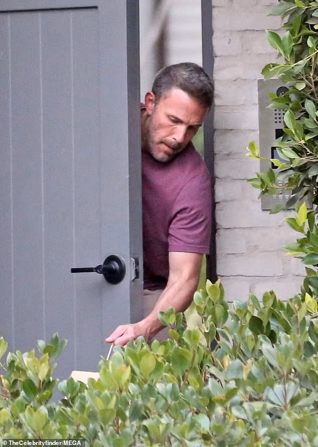 Ben Affleck lấy đồ ăn nhanh đặt trước cổng sau nhà thuê. Ảnh: Mega.