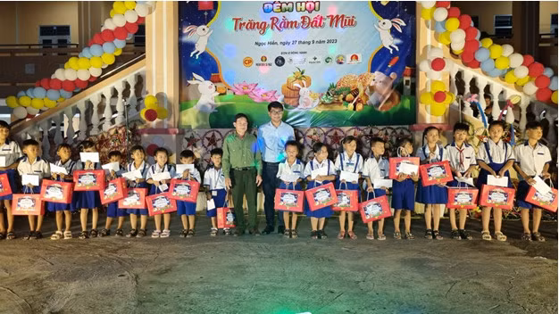 Anh Trần Đăng Khoa - Phó Bí thư Tỉnh Đoàn (bên phải) và ông Đỗ Văn Đồng, Phó Giám đốc Vườn Quốc gia Mũi Cà Mau trao tặng quà và học bổng cho các em có hoàn cảnh khó khăn.
