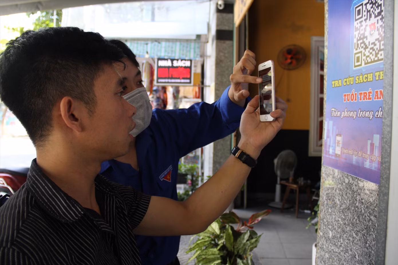 Các tình nguyện viên Đoàn phường hướng dẫn bạn trẻ quét mã và tìm sách trong thư viện Ảnh: Giang Thanh