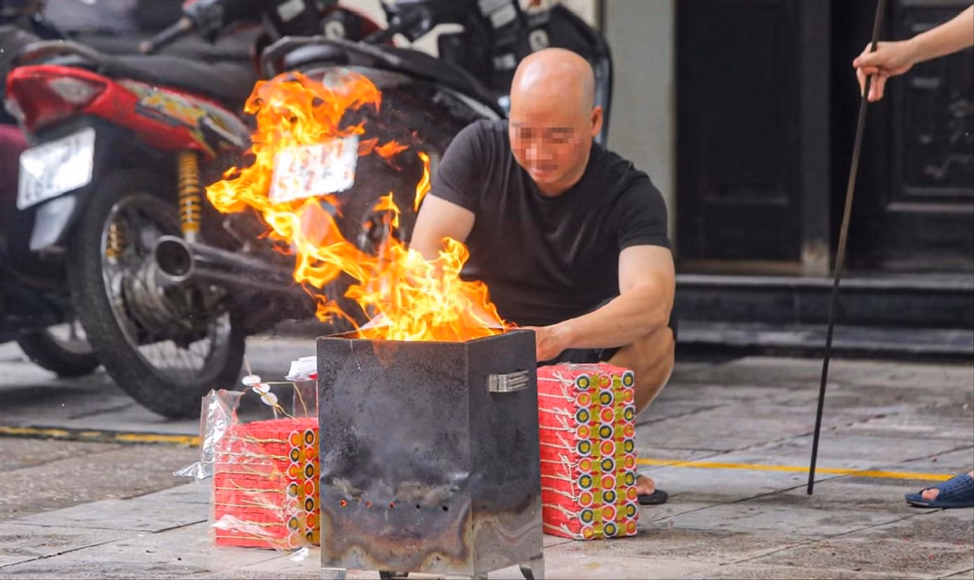 Người dân có thói quen sắp mâm lễ cúng, đốt vàng mã ngay tại vỉa hè, lòng đường. Ảnh: DUY PHẠM