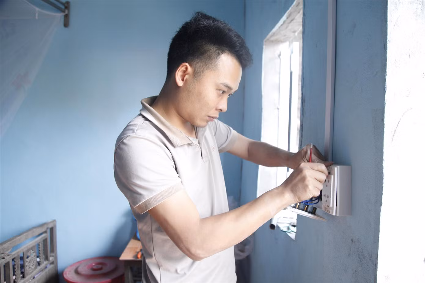 Đoàn viên Trường Cao đẳng Kỹ thuật Công nghiệp Bắc Giang làm đường dây điện giúp nhà bà Lường Thị Mèo. Ảnh: Nguyễn Thắng