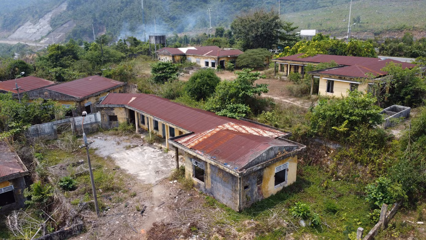 Một góc khu đất với các dãy nhà chức năng bỏ hoang cây cối, cỏ dại mọc thành rừng.