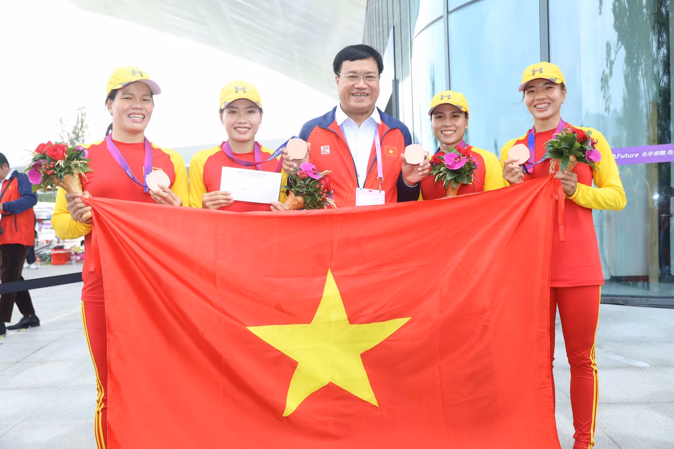 Trưởng đoàn Đặng Hà Việt thưởng nóng cho tấm huy chương Asiad 19 đầu tiên. Ảnh: Quý Lượng