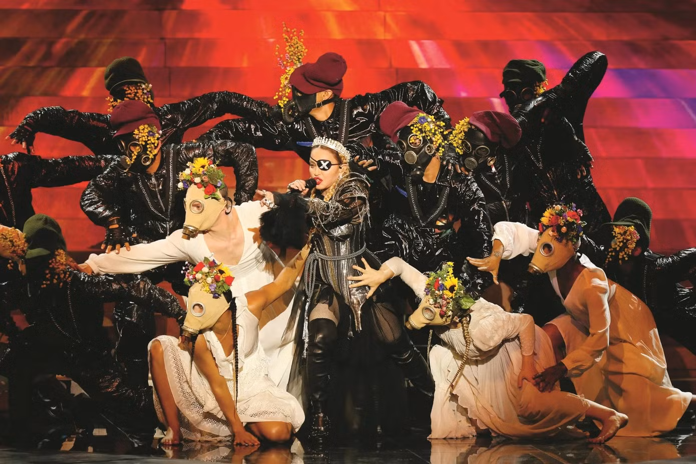 Cô cũng biểu diễn tại Eurovision Song Contest năm 2019 và vẫn xuất hiện phong cách táo bạo hơn bao giờ hết - bộ bodysuit bằng da có tay áo bằng vải tuyn, quần tất lưới và bốt da cao đến đùi. Cô đội chiếc vương miện bạc và một miếng che mắt màu đen có chữ X trên đó, được lấy cảm hứng từ album phòng thu thứ 14, Madame X. Madonna có thể ngày một lớn tuổi hơn nhưng thời trang của cô vẫn nổi loạn và đặc biệt. Ảnh: SCMP.