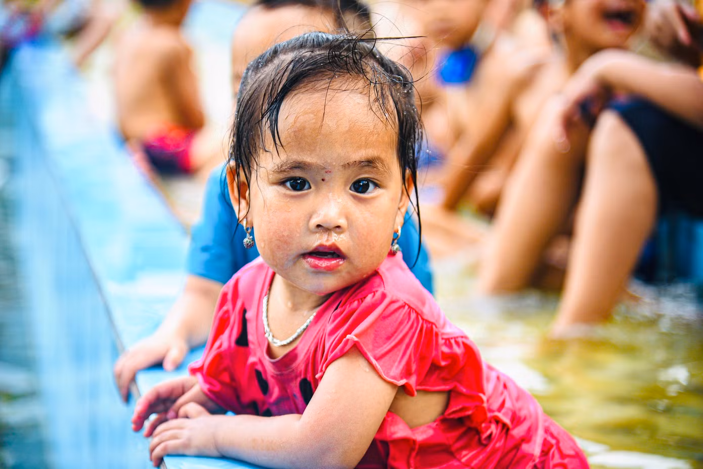 Nhiều em nhỏ trong thôn thích thú bơi lội, vẫy vùng trong làn nước xanh mát.
