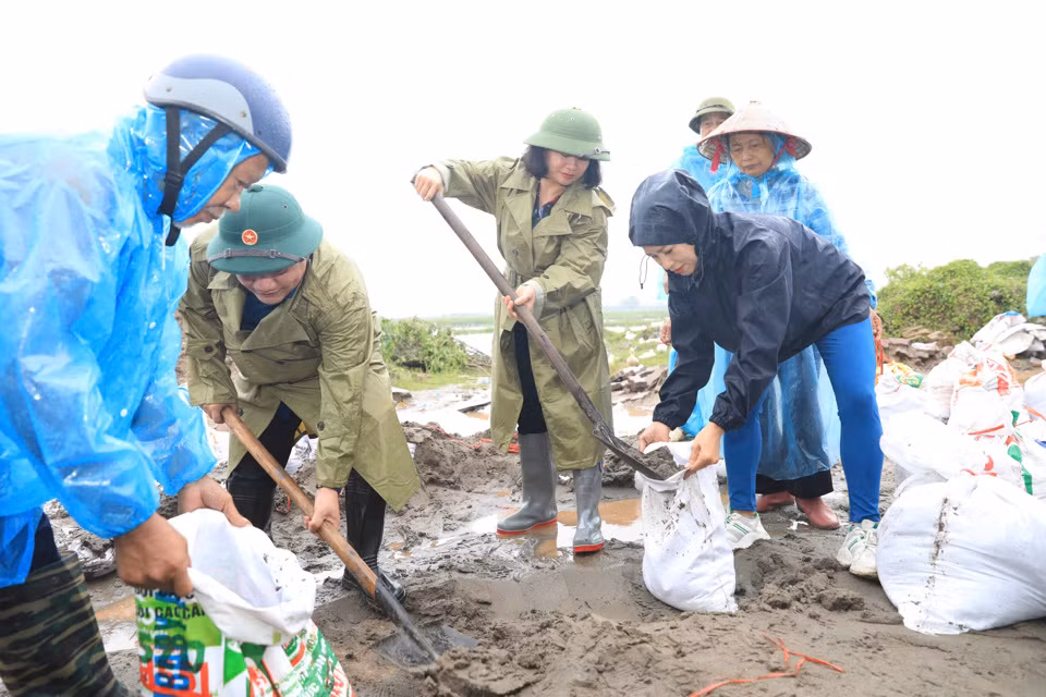 Phó Bí thư Nguyễn Thị Tuyến cùng các lực lượng chức năng chuẩn bị bao cát, sẵn sàng cho tình huống khẩn cấp tại khu vực đê xung yếu xã Đại Áng, huyện Thanh Trì.