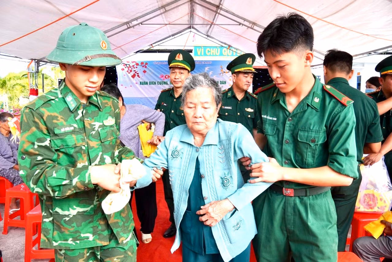Cán bộ, chiến sĩ hỗ trợ người dân khám bệnh.