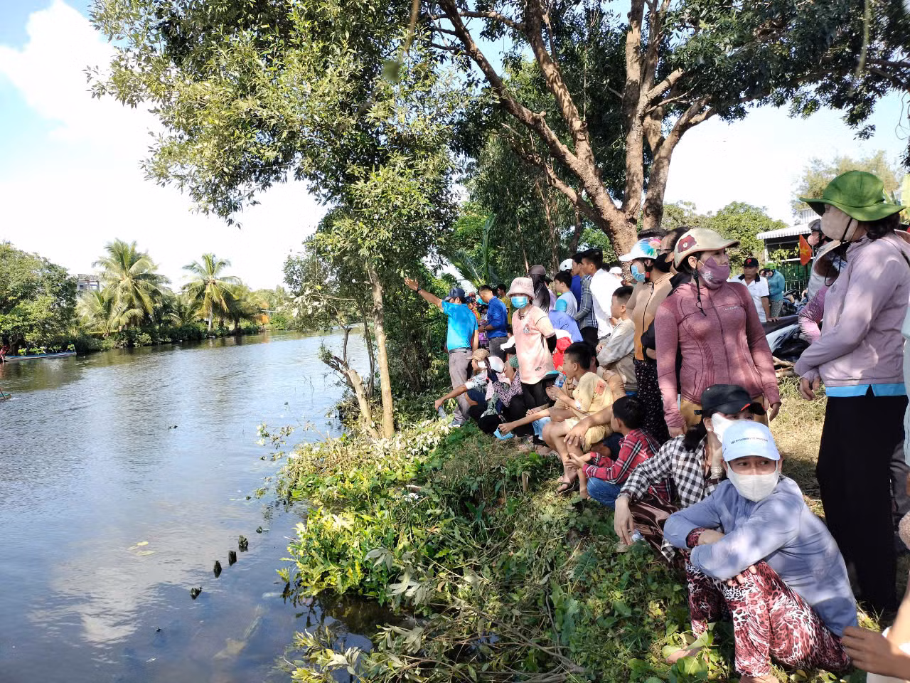 Đông đảo người dân đứng dọc hai bên bờ sông theo dõi, cổ vũ các đội đua.