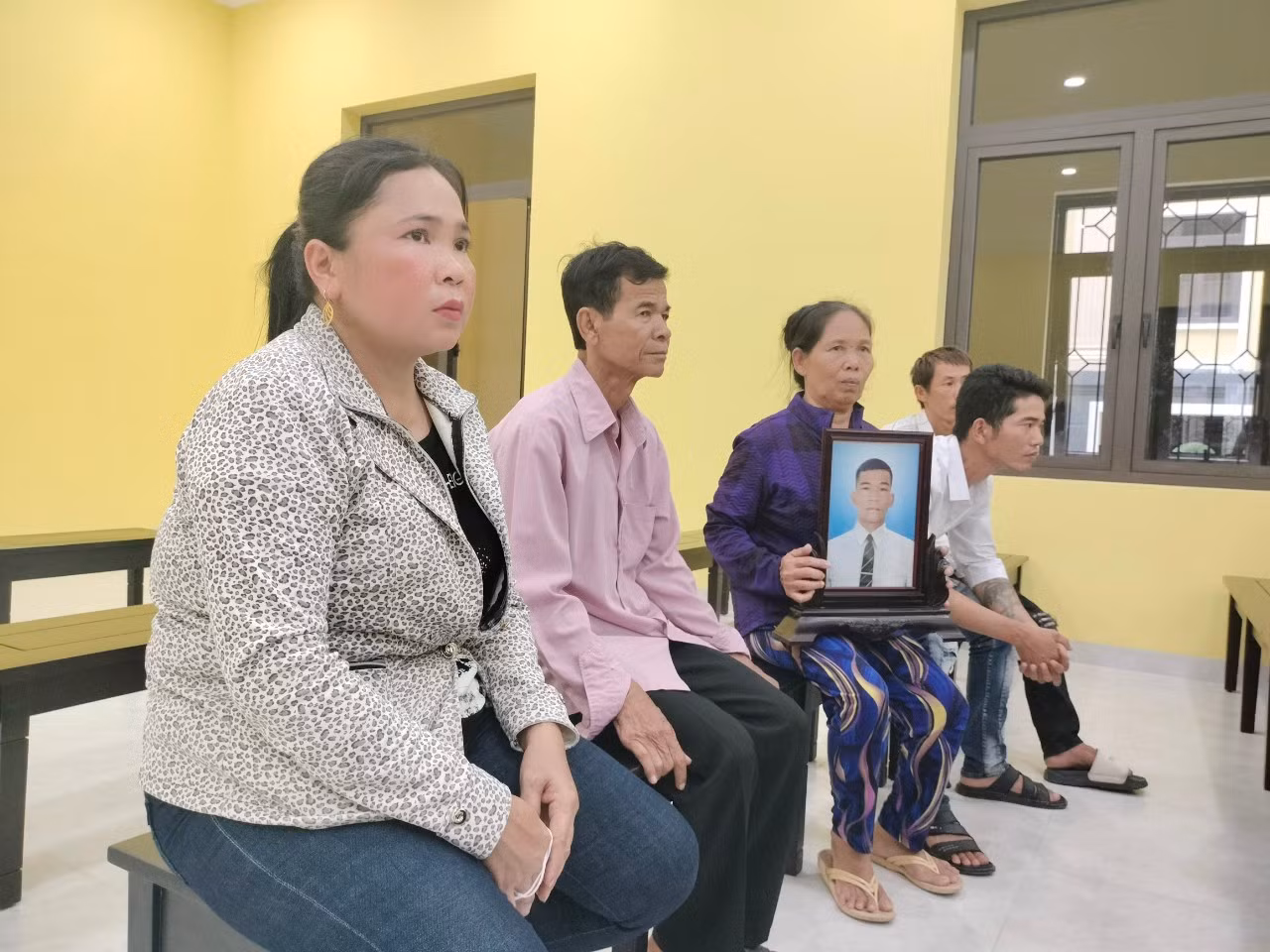 Gia đình bị hại mang di ảnh nạn nhân đến phiên tòa.