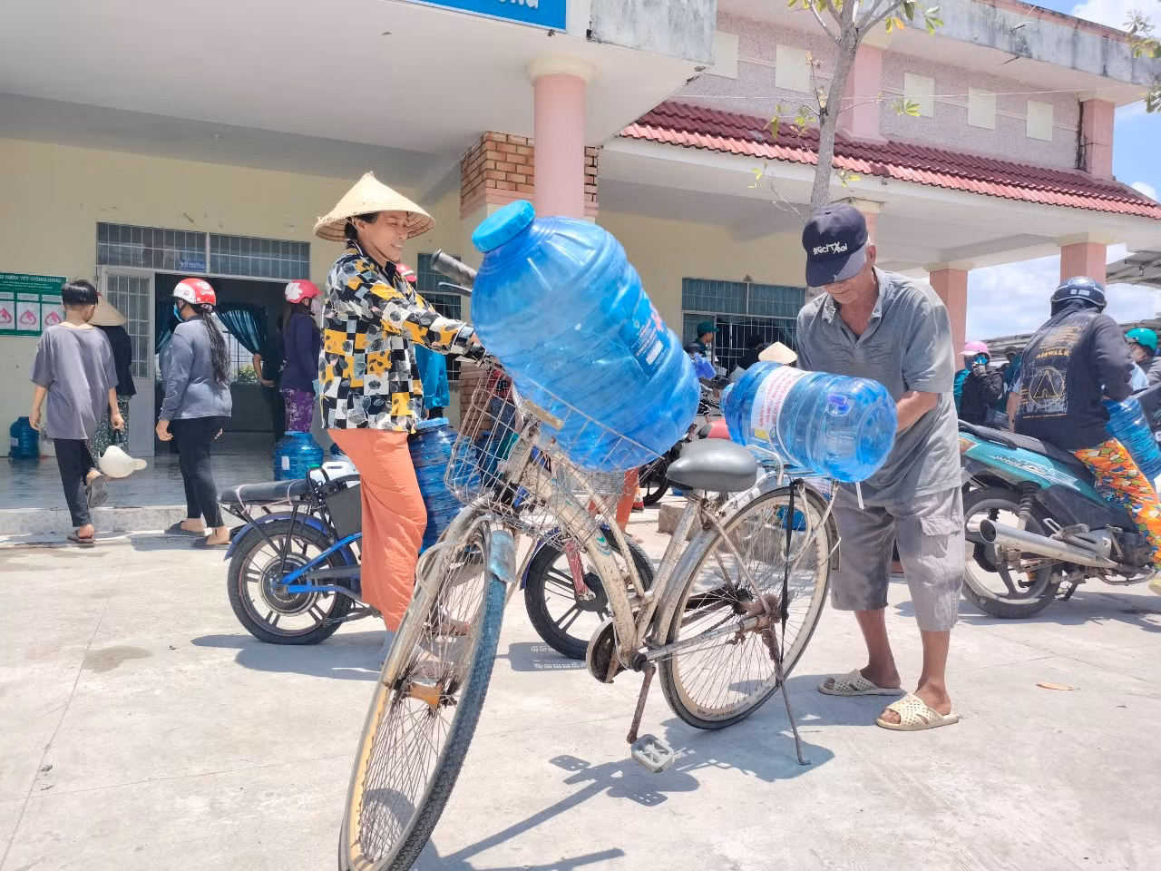 Chở nước lọc bằng xe đạp mang về nhà.