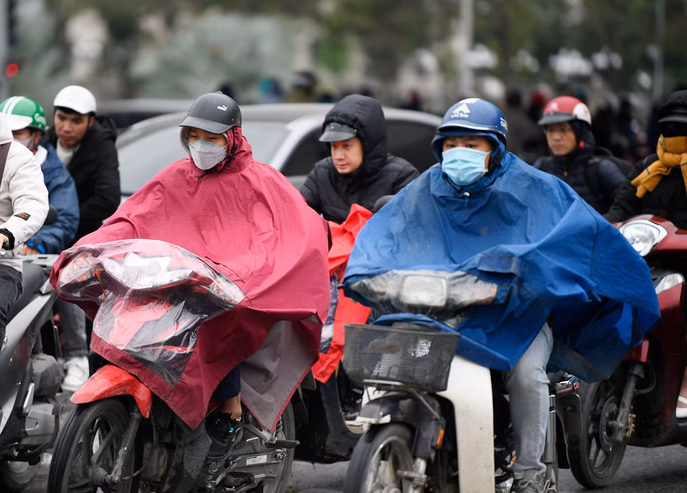 Người dân khi đi ra đường đều mặc ấm, thậm chí trùm kín áo mưa trước đợt không khí lạnh lần này.