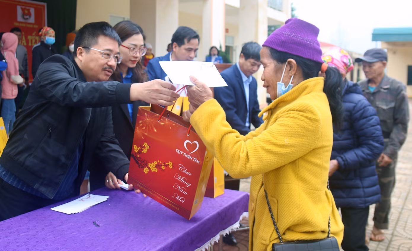 Nhà báo Vũ Tiến và chị Phùng Tố Linh, cùng đại diện lãnh đạo địa phương trao tặng quà tới các hộ gia đình tại chương trình. Ảnh: Hoàng Lam