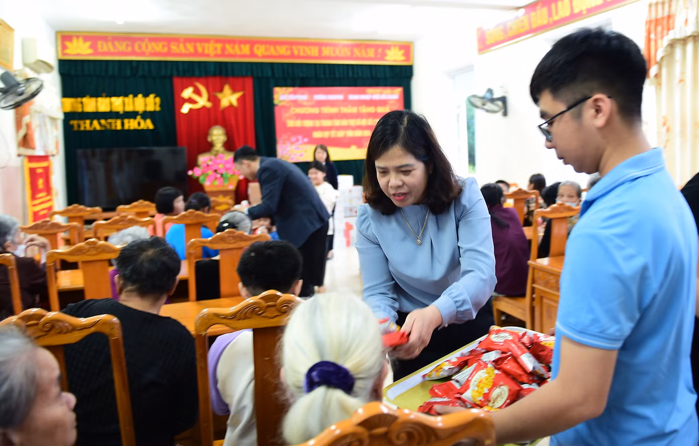 Bà Phạm Thị Hoài - Phó Hiệu trưởng Trường liên cấp Fansipan Thanh Hóa trao tặng quà tiền mặt; nhà báo Lê Xuân Sơn trao phần quà của doanh nghiệp Dược Đức Khánh tới Trung tâm Bảo trợ xã hội II tỉnh Thanh Hóa. Bà Nguyễn Hồng Thủy đang được chăm sóc tại Trung tâm Bảo trợ xã hội II bày tỏ: "Mỗi lần Tết đến Xuân, các anh chị đến chúc mừng, chúng tôi cảm thấy rất phấn khởi, ấm lòng". Ảnh: Xuân Tùng
