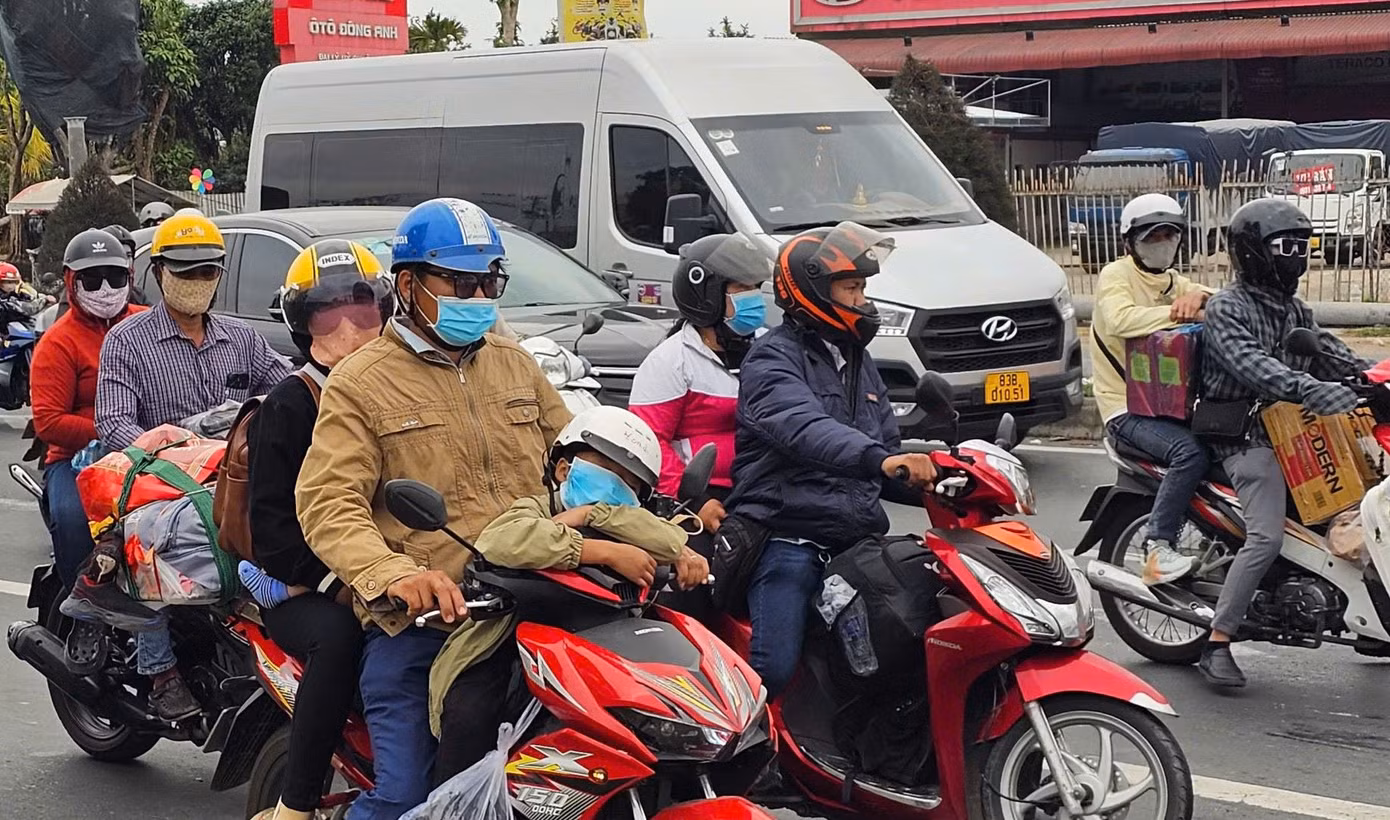 Trẻ em vật vã trên xe gắn máy cùng cha mẹ. Ảnh: Hòa Hội