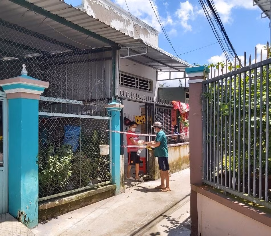 Trao tặng chè cho người dân khu phong tỏa phường Trà Nóc, quận Bình Thủy. - Ảnh: Hòa Hội