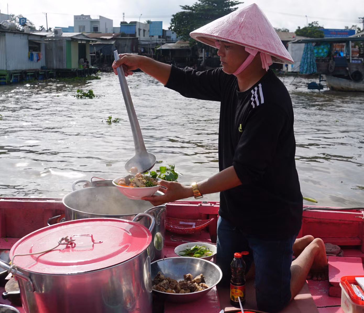 Vợ chồng anh Quốc sống cặp mé sông với nghề bán bún riêu tại chợ nổi Cái Răng (phường Lê Bình, quận Cái Răng, TP Cần Thơ) gần chục năm nay. Anh Quốc cho biết, khoảng 2 giờ sáng, vợ chồng thức dậy chuẩn bị nấu nướng, đến hơn 4 giờ chạy ra giữa sông, ngay chợ nổi để bán bún riêu. - Ảnh: Hòa Hội Khi dịch COVID-19 bùng phát, vợ chồng anh tạm nghỉ, cho đến khi dịch bệnh lắng, du lịch hồi phục, vợ chồng anh nghĩ ra cách tạo điểm nhấn thú vị cho du khách bằng cách sơn lại toàn bộ chiếc ghe và vật dụng đi kèm như nắp nồi, nón lá... - Ảnh: Hòa Hội Anh Quốc cho biết, màu hồng là màu vợ yêu thích từ nhỏ nên khi vợ có ý tưởng là ủng hộ ngay rồi vợ chồng cùng sơn lại toàn bộ ghe và các vật dụng. - Ảnh: Hòa Hội Vừa loay hoay làm tô bún cho khách, chị Linh chia sẻ: “Màu hồng tôi yêu thích từ nhỏ, bởi gần gũi và dễ thương. Hơn nữa, các ghe ở đây giống nhau nên tôi muốn tạo điểm nhấn để du khách đến tham quan, ăn uống và chụp ảnh". Các vật dụng đi kèm đều được vợ chồng chị Linh sơn màu hồng. - Ảnh: Hòa Hội Trước đây, mỗi ngày vợ chồng anh chị bán khoảng 50 tô bún, nhưng từ khi "khoác áo mới" gây sự chú ý cho nhiều người, đặc biệt là các bạn trẻ đưa lên mạng xã hội, giờ mỗi ngày bán gấp 2 – 3 lần; thời điểm khách đông nhất là khoảng 6 đến hơn 7 giờ mỗi ngày. Chị Lan, du khách đến từ Hà Nội cho biết, xem trên mạng thấy chợ nổi có ghe bán bún màu hồng dễ thương nên đến đây tham quan và thưởng thức bún trên sông. Chiếc ghe dễ thương, thức ăn ngon và giá cả cũng không quá đắt. - Ảnh: Hòa Hội Du khách chụp ảnh tại chợ nổi Cái Răng. Chiếc ghe màu hồng nổi bật giữa chợ nổi giúp vợ chồng anh Quốc, chị Linh bán hơn trăm tô bún riêu mỗi ngày. - Ảnh: Hòa Hội