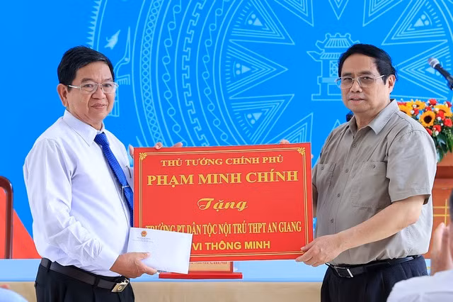Thủ tướng tặng quà cho các thầy cô giáo, học sinh trường Phổ thông Dân tộc nội trú THPT An Giang. Ảnh: VGP