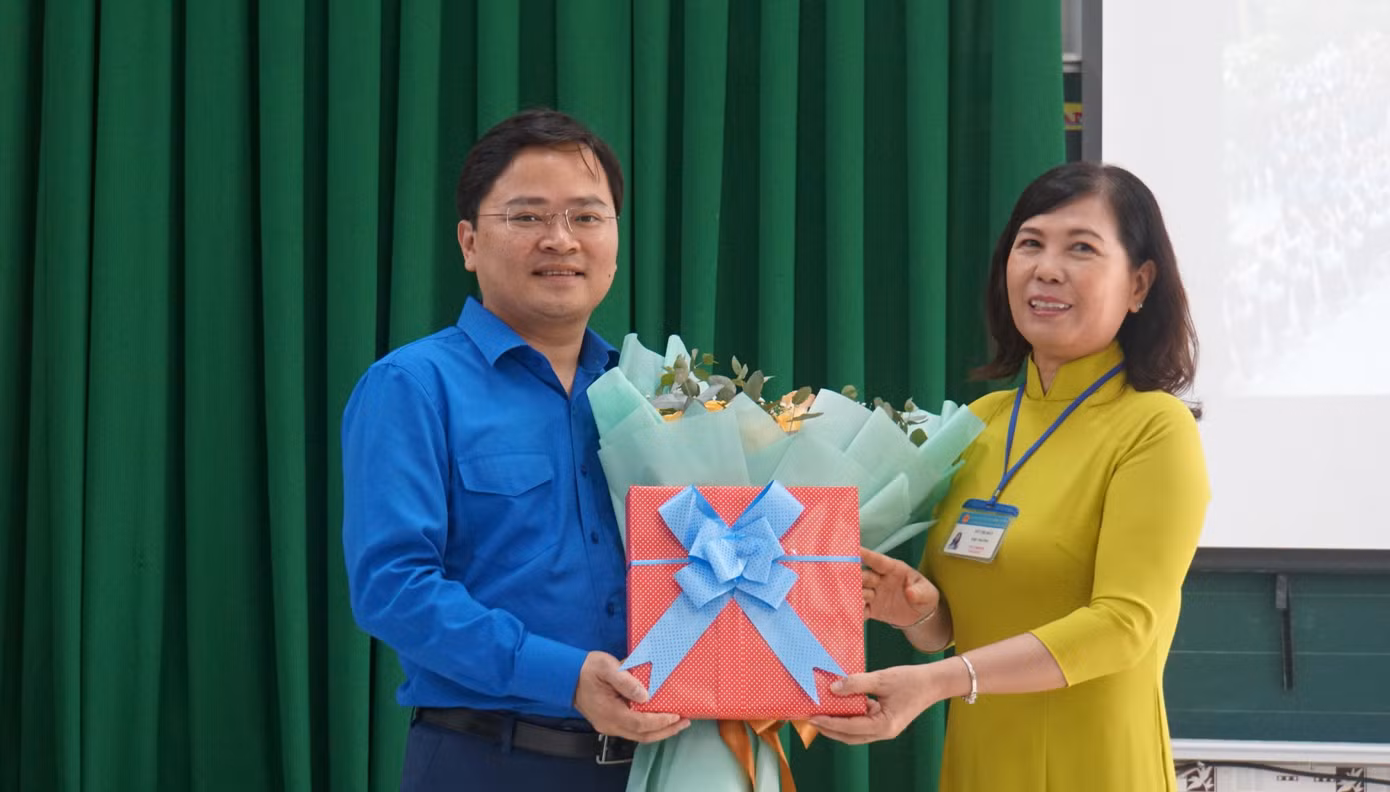 Cô Tô Thị Bảy, Hiệu trưởng trường Tiểu học Thiên Hộ Dương tặng hoa Bí thư thứ nhất Trung ương Đoàn Nguyễn Anh Tuấn. - Ảnh: Hòa Hội