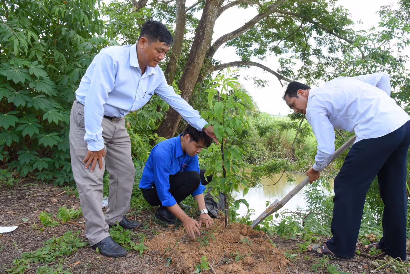 Cán bộ địa phương và ĐVTN trồng cây xanh trên tuyến đường nông thôn tại xã Tân Kiều. Ảnh: Hòa Hội