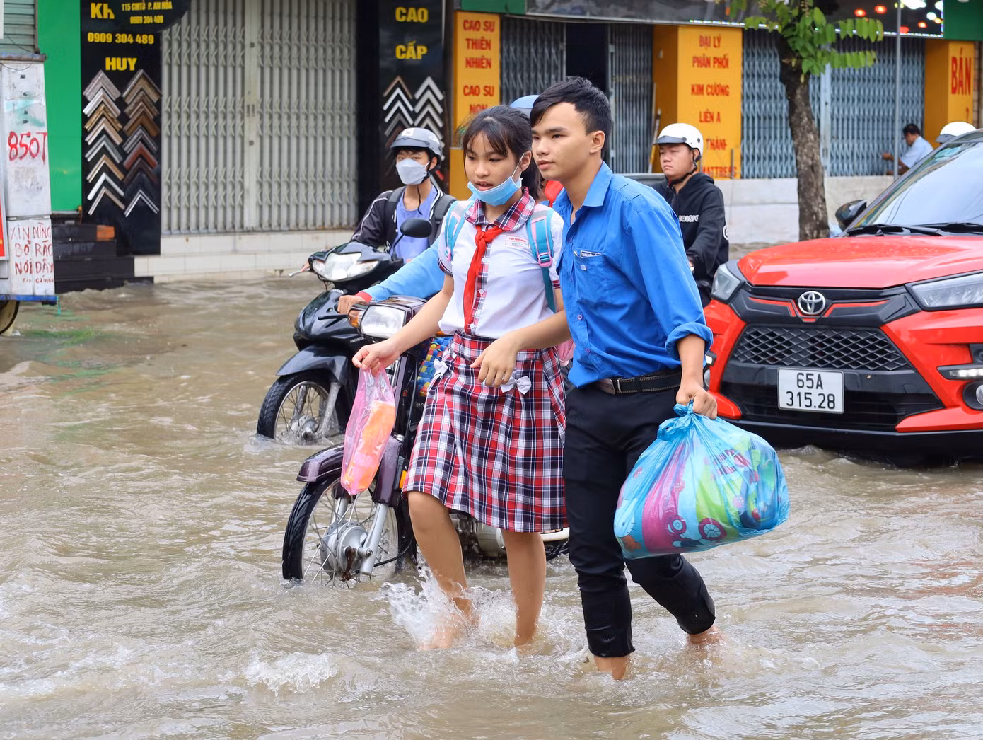 Đoàn viên thanh niên quận Ninh Kiều hỗ trợ giúp người dân vượt qua đoạn bị ngập.