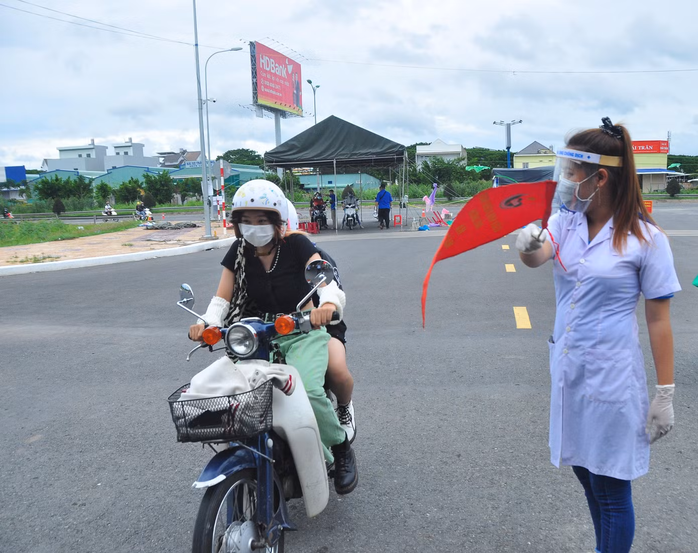 Ngọc Ánh dáng người nhỏ nhắn nhưng nhanh nhẹn, hoạt bát và rất nhiệt tình trong công việc hỗ trợ người dân khai báo y tế cũng như hướng dẫn người dân vào vị trí khai báo.