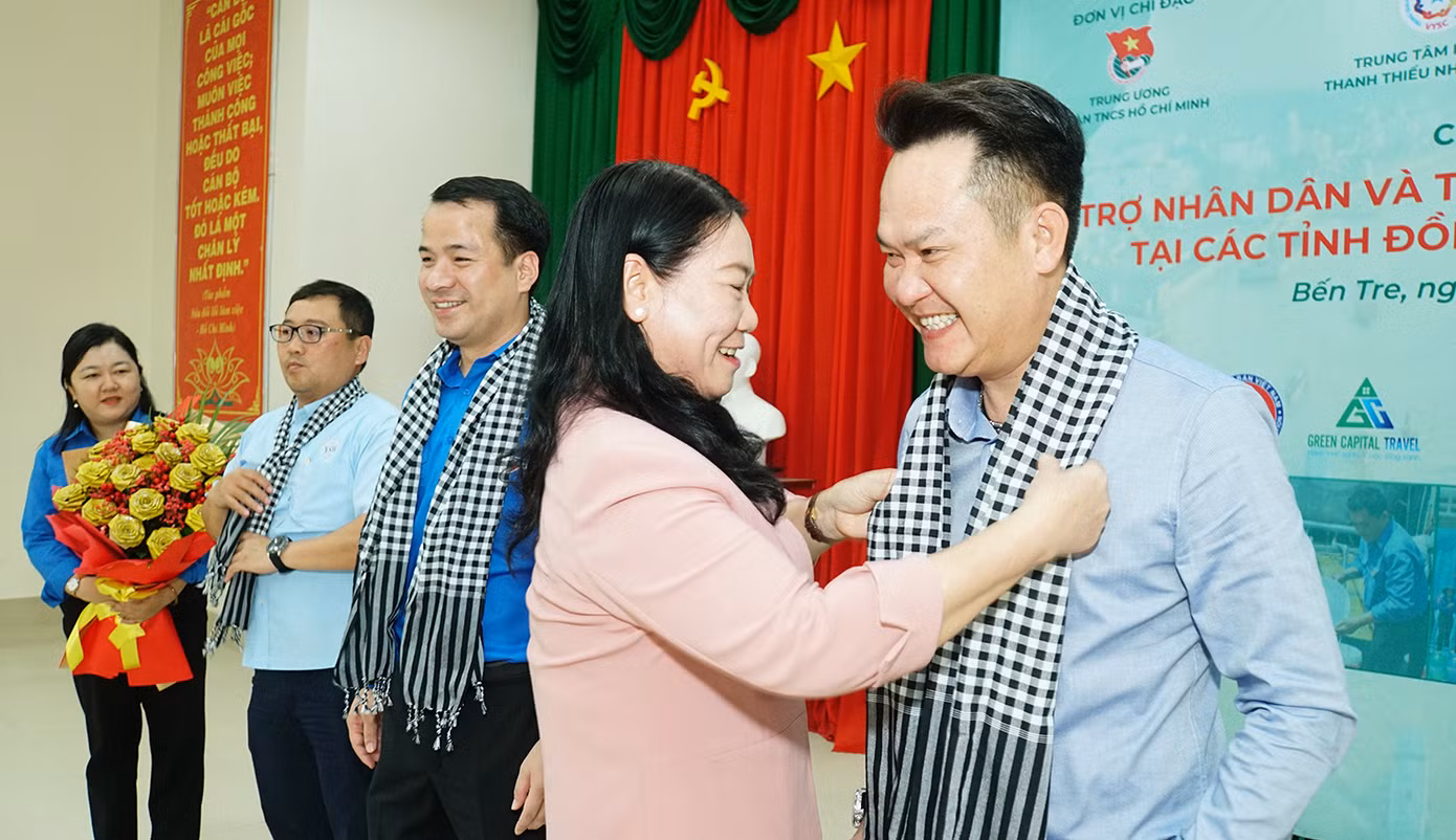 Bà Nguyễn Thị Bé Mười, Phó chủ tịch UBND tỉnh Bến Tre tặng khăn cho ông Đặng Hồng Anh. Ảnh: Hòa Hội