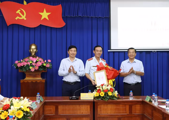 Chủ tịch UBND tỉnh Đồng Tháp (trái) trao quyết định cho ông Nguyễn Văn Nghĩa (giữa). Ảnh: N. Ánh.