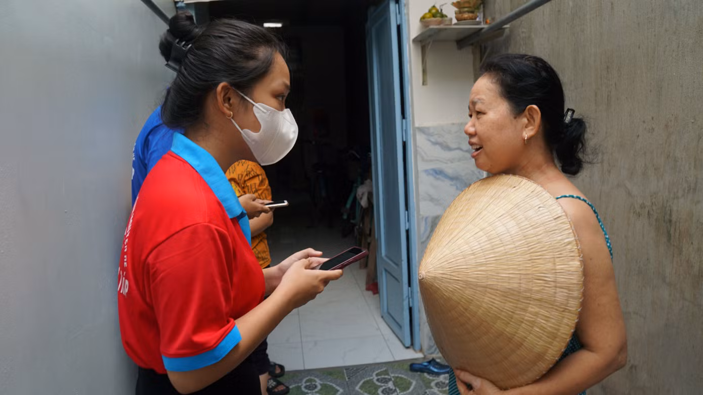 Sinh viên tình nguyện hỗ trợ người dân cài đặt ứng dụng điện tử.