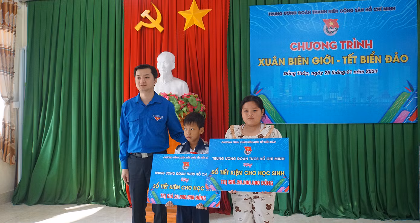 Bí thư Trung ương Đoàn Nguyễn Minh Triết tặng sổ tiết kiệm cho 2 em học sinh có hoàn cảnh khó khăn, vượt khó học giỏi, mỗi sổ trị giá 20 triệu đồng. Ảnh: Hòa Hội