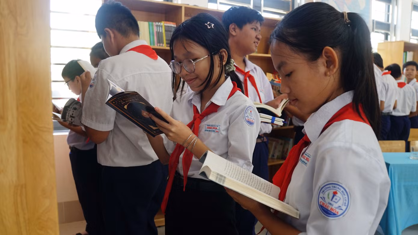 Các em học sinh chăm chú đọc sách.