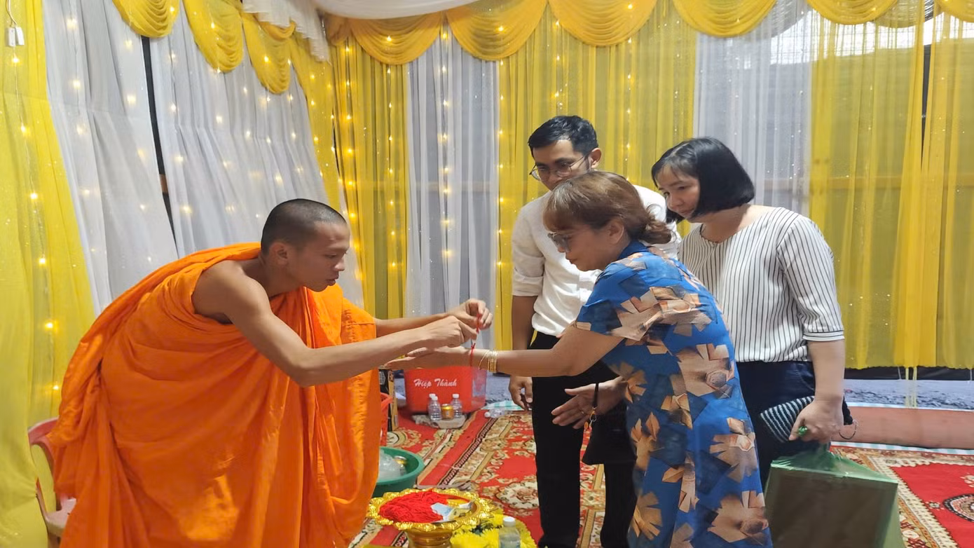 Sư trong chùa đeo chỉ đỏ cho du khách cầu mong may mắn, bình an và thể hiện sự đoàn kết, gắn bó của cộng đồng. Ảnh: Hòa Hội.