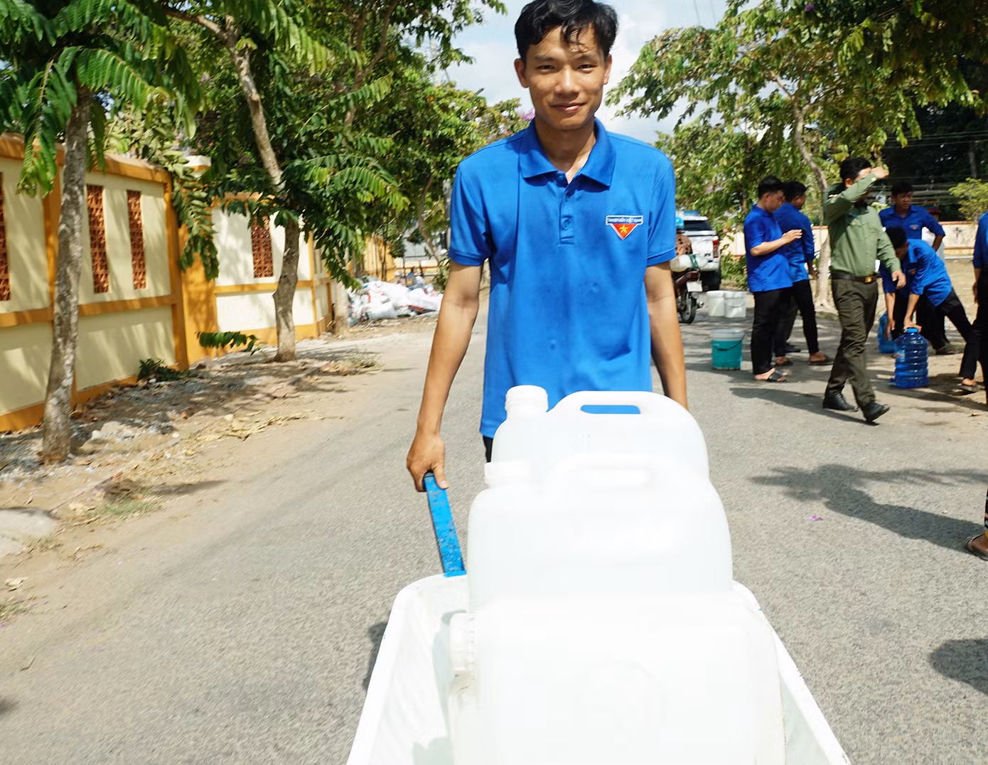 Đoàn viên thanh niên đẩy xe chở nước đến tận nhà giúp người dân tại huyện Ba Tri. Ảnh: Hòa Hội