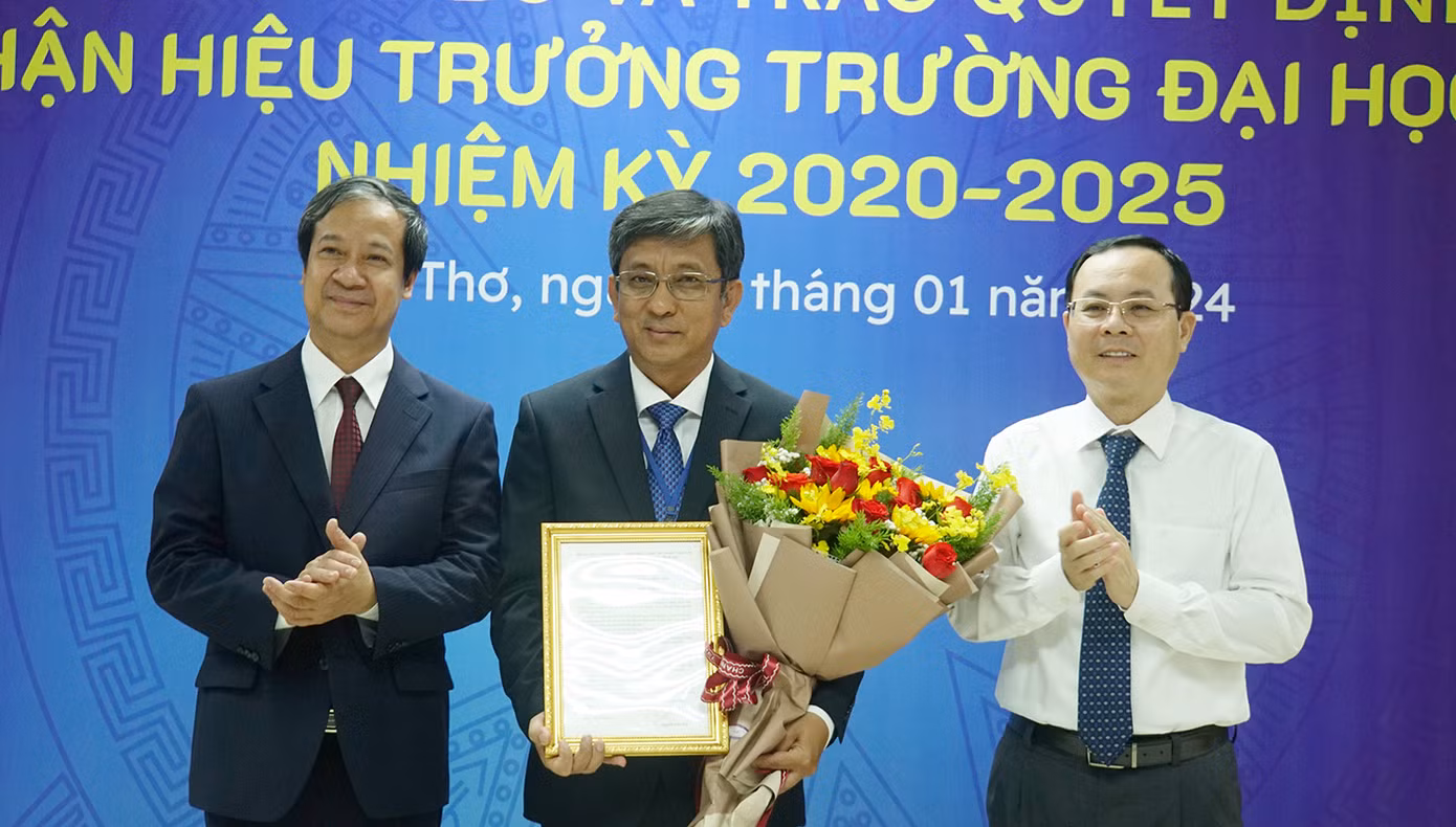 Bộ trưởng Bộ GD&amp;ĐT Nguyễn Kim Sơn (trái) cùng Bí thư Thành ủy Cần Thơ Nguyễn Văn Hiếu trao quyết định và tặng hoa chúc mừng PGS.TS Trần Trung Tính - Hiệu trưởng Trường Đại học Cần Thơ. Ảnh: Hòa Hội.