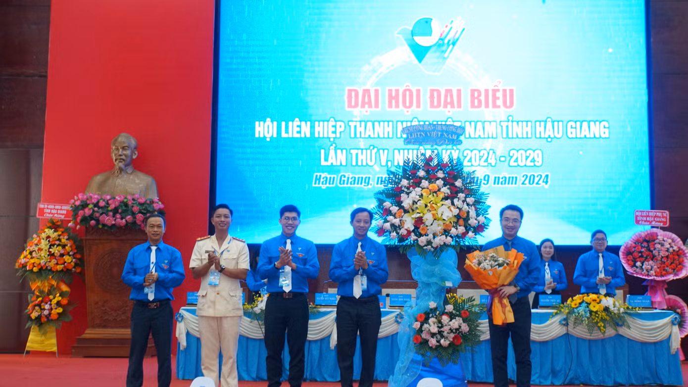 Anh Trương Minh Hoàng - Chủ tịch Hội LHTN Việt Nam tỉnh Hậu Giang (thứ 4 từ trái sang) tặng hoa Bí thư Trung ương Đoàn. Ảnh: Hòa Hội